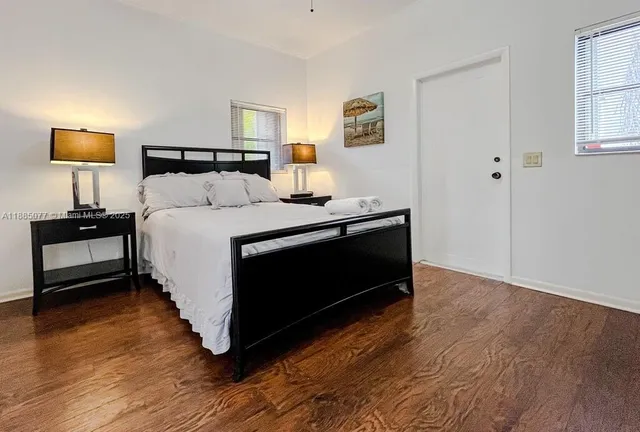 a bedroom with a bed and a lamp on the dresser