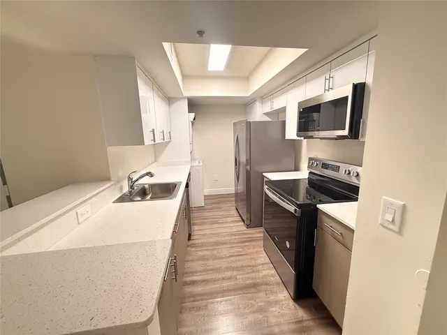 a kitchen with stainless steel appliances a refrigerator stove microwave and sink