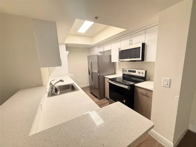 a kitchen with kitchen island a sink stainless steel appliances and cabinets