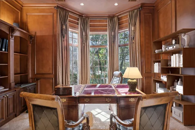 a view of a workspace with furniture and a window