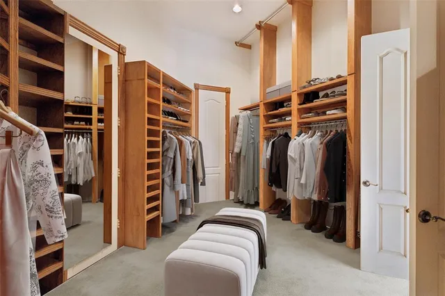 a view of walk in closet with clothes and shoes