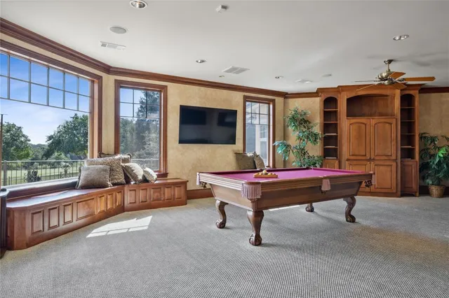 a living room with furniture a flat screen tv and a floor to ceiling window