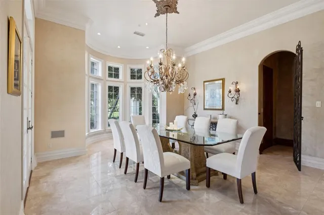 a dining room with furniture a chandelier and window