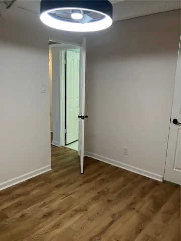 an empty room with wooden floor and entrance