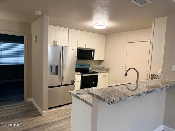 a kitchen with granite countertop a refrigerator and a sink
