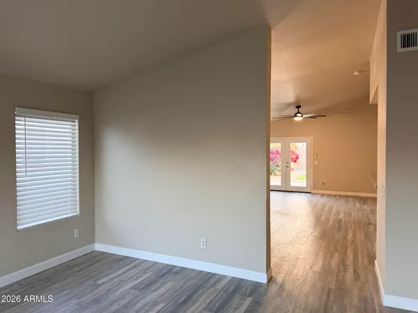 an empty room with wooden floor and windows
