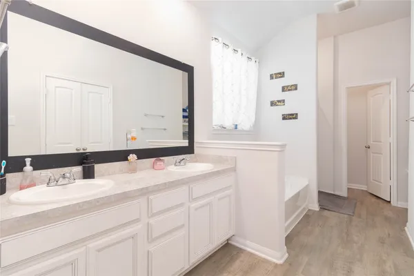 a bathroom with a double vanity sink and mirror