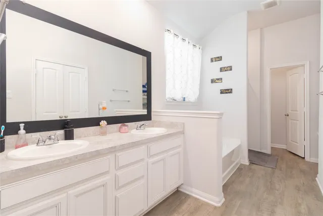 a bathroom with a double vanity sink and mirror