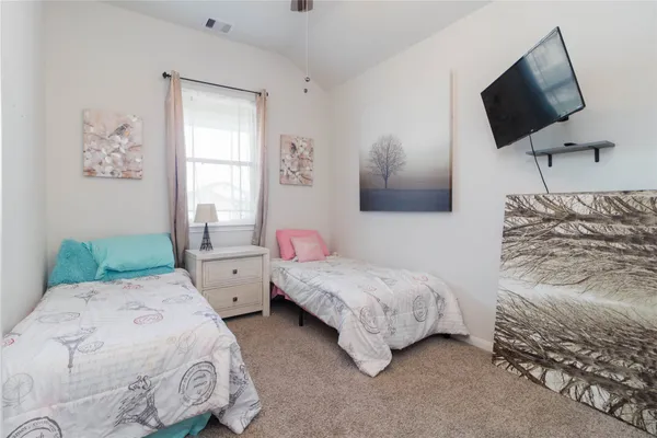 a bedroom with two beds and a flat screen tv