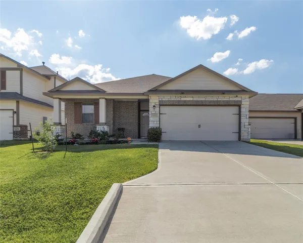 a front view of a house with a garden and plants