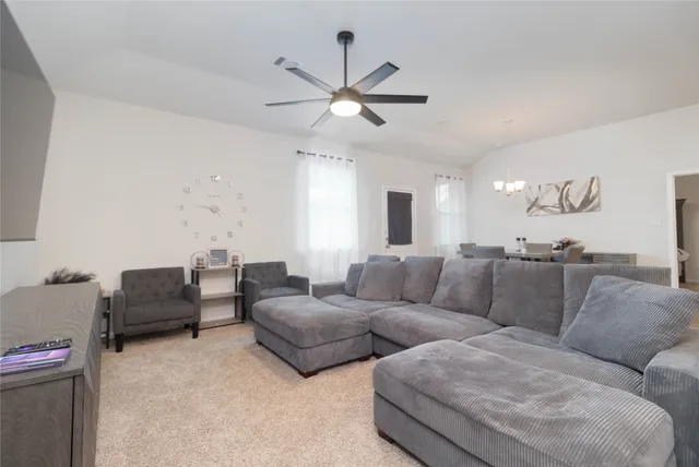 a living room with furniture and a ceiling fan