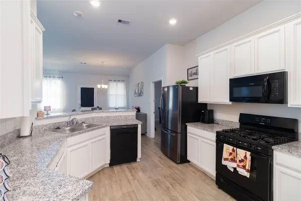 a kitchen with stainless steel appliances a stove a sink and a refrigerator