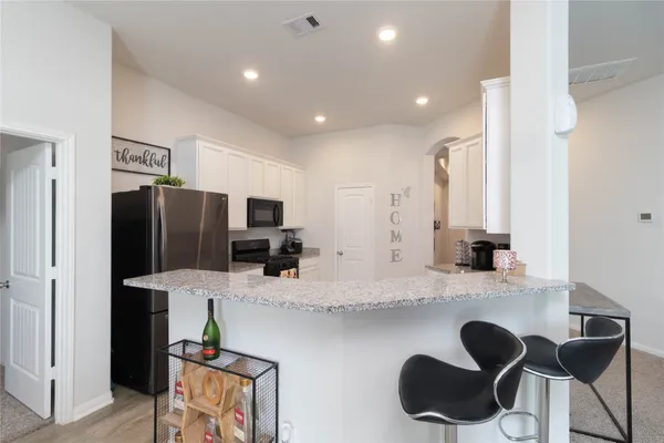 a kitchen with granite countertop cabinets and refrigerator