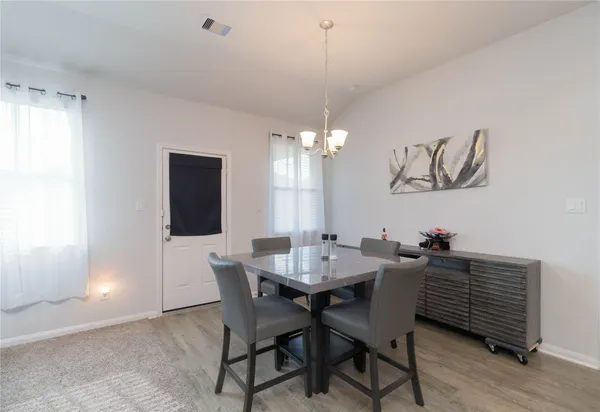 a view of a dining room with furniture and chandelier