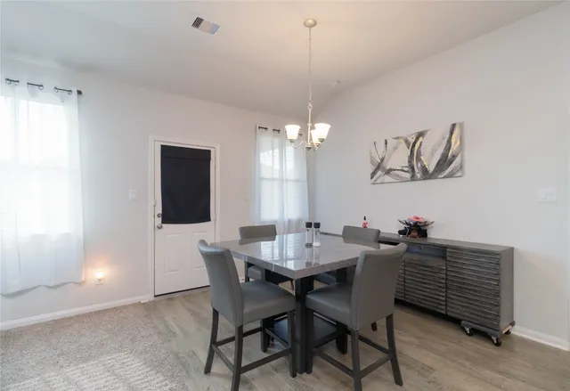 a view of a dining room with furniture and chandelier