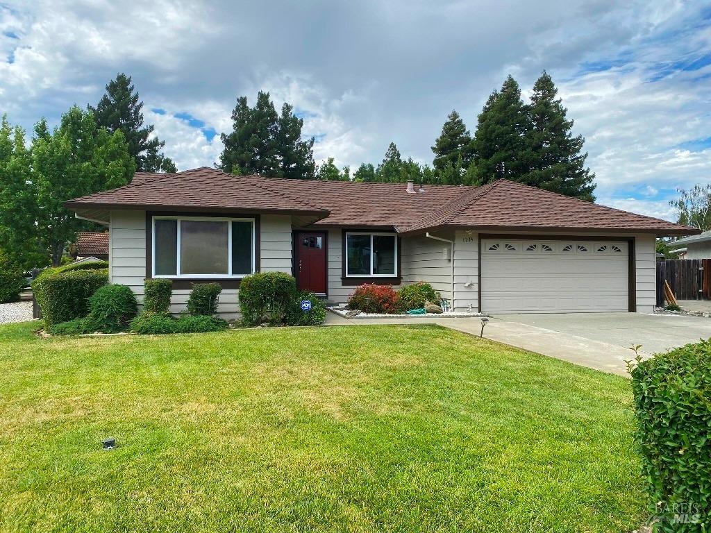 a front view of a house with a yard and trees