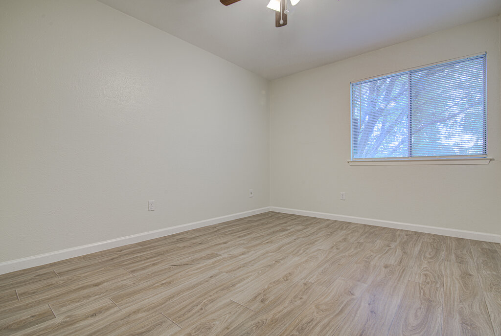 5301 Indio Circle, Unit A Austin, TX 78745 - Photo 11 of 25 A well-lit bedroom with durable wood-look flooring and a window offering natural illumination.