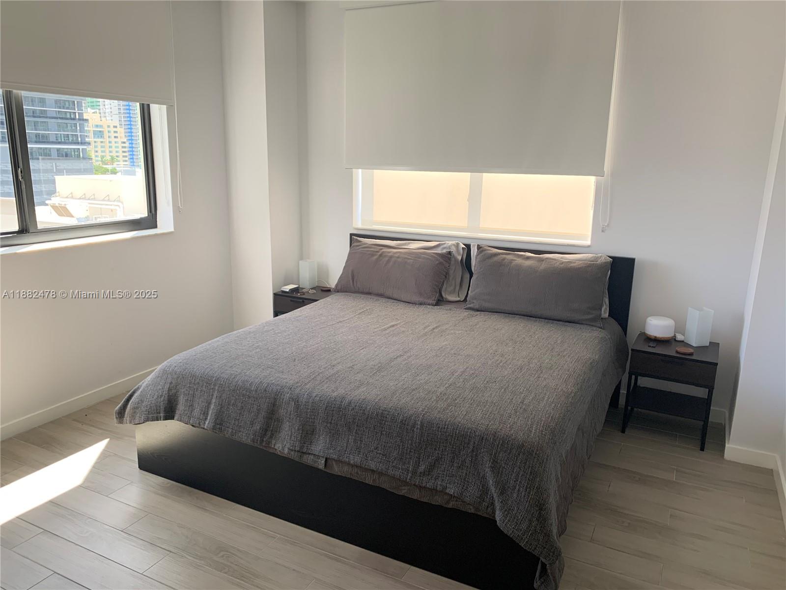 999 Southwest 1st Avenue, Unit 1703 Miami, FL 33130 - Photo 11 of 28 a bed sitting in a bedroom next to a window