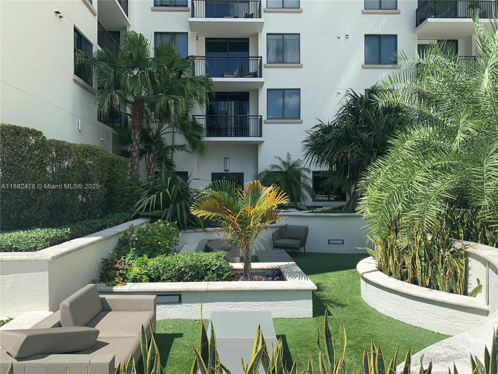 999 Southwest 1st Avenue, Unit 1703 Miami, FL 33130 - Photo 17 of 28 a view of a patio with table and chairs potted plants and floor to ceiling window