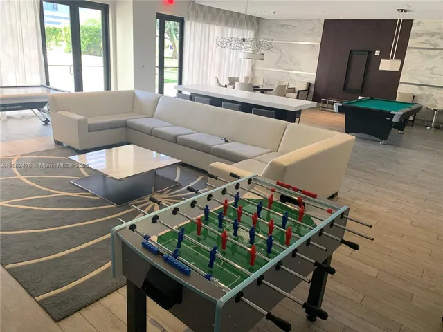 a living room with furniture pool table and a large window
