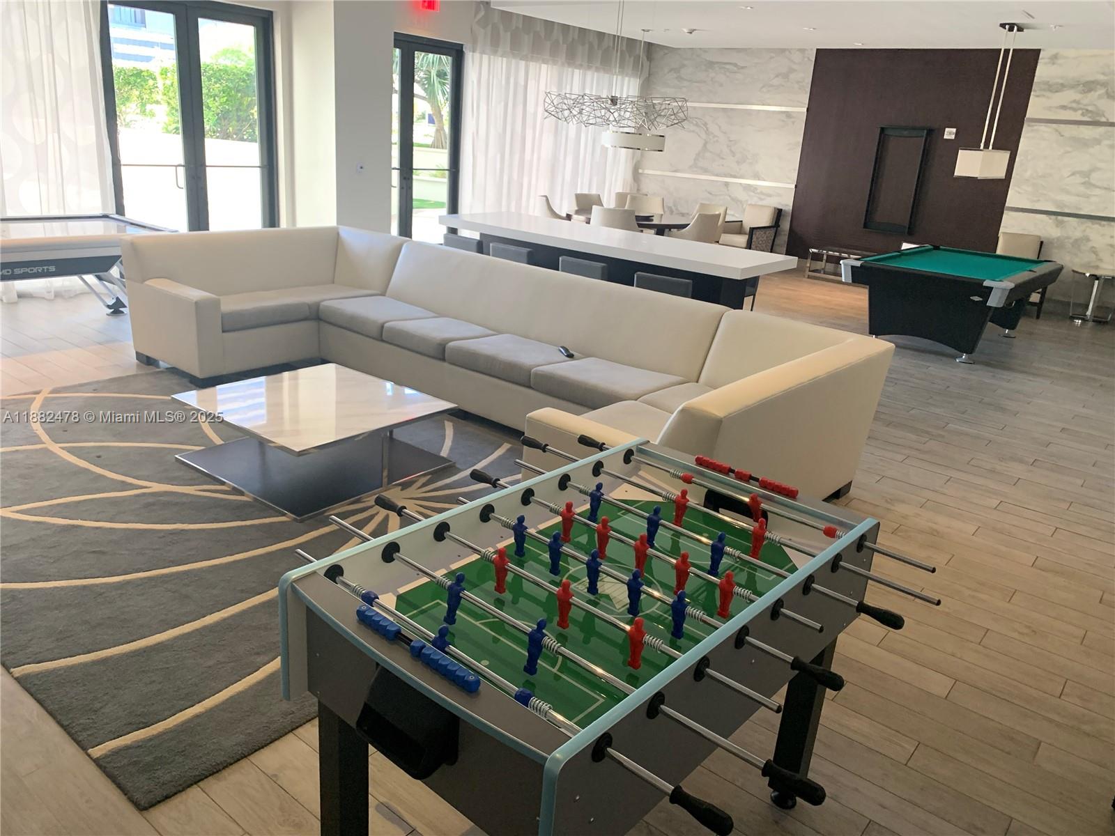 999 Southwest 1st Avenue, Unit 1703 Miami, FL 33130 - Photo 22 of 28 a living room with furniture pool table and a large window