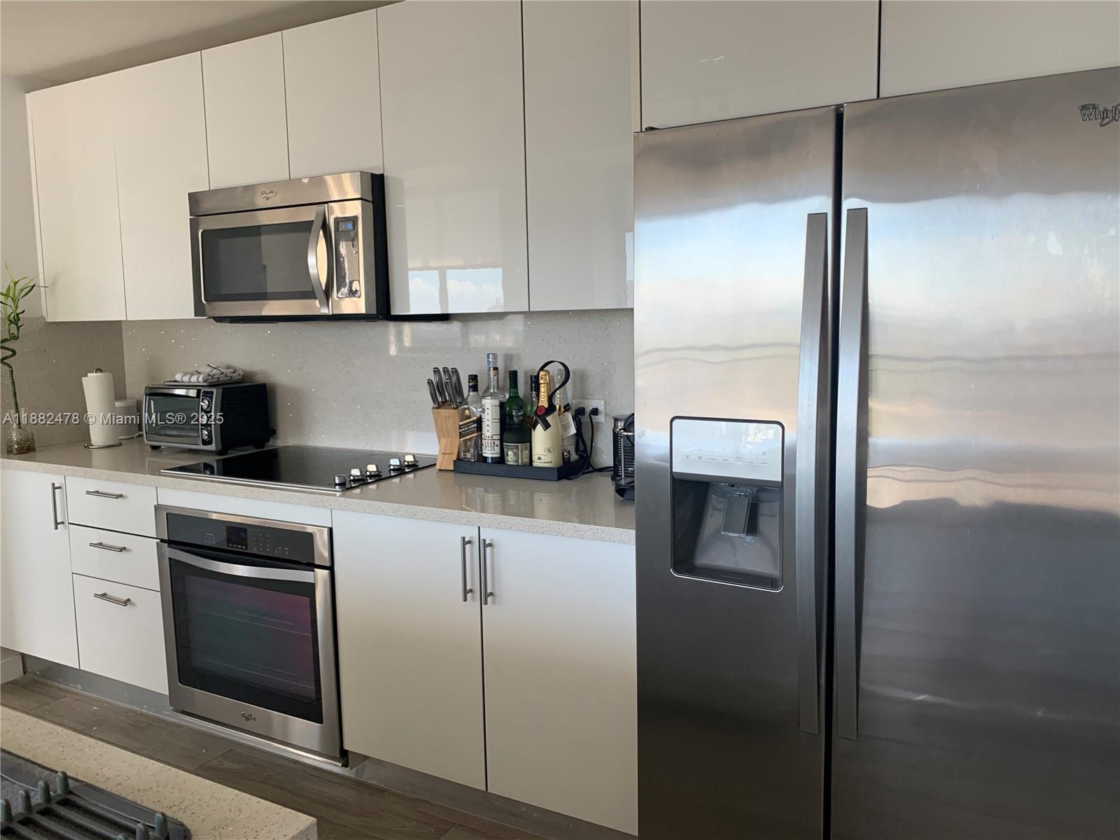 999 Southwest 1st Avenue, Unit 1703 Miami, FL 33130 - Photo 5 of 28 a kitchen with a refrigerator and microwave