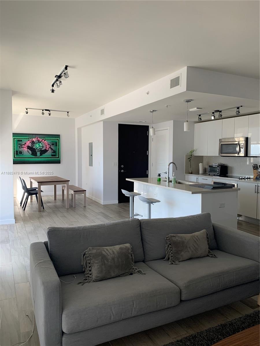 999 Southwest 1st Avenue, Unit 1703 Miami, FL 33130 - Photo 6 of 28 a living room with furniture and a flat screen tv