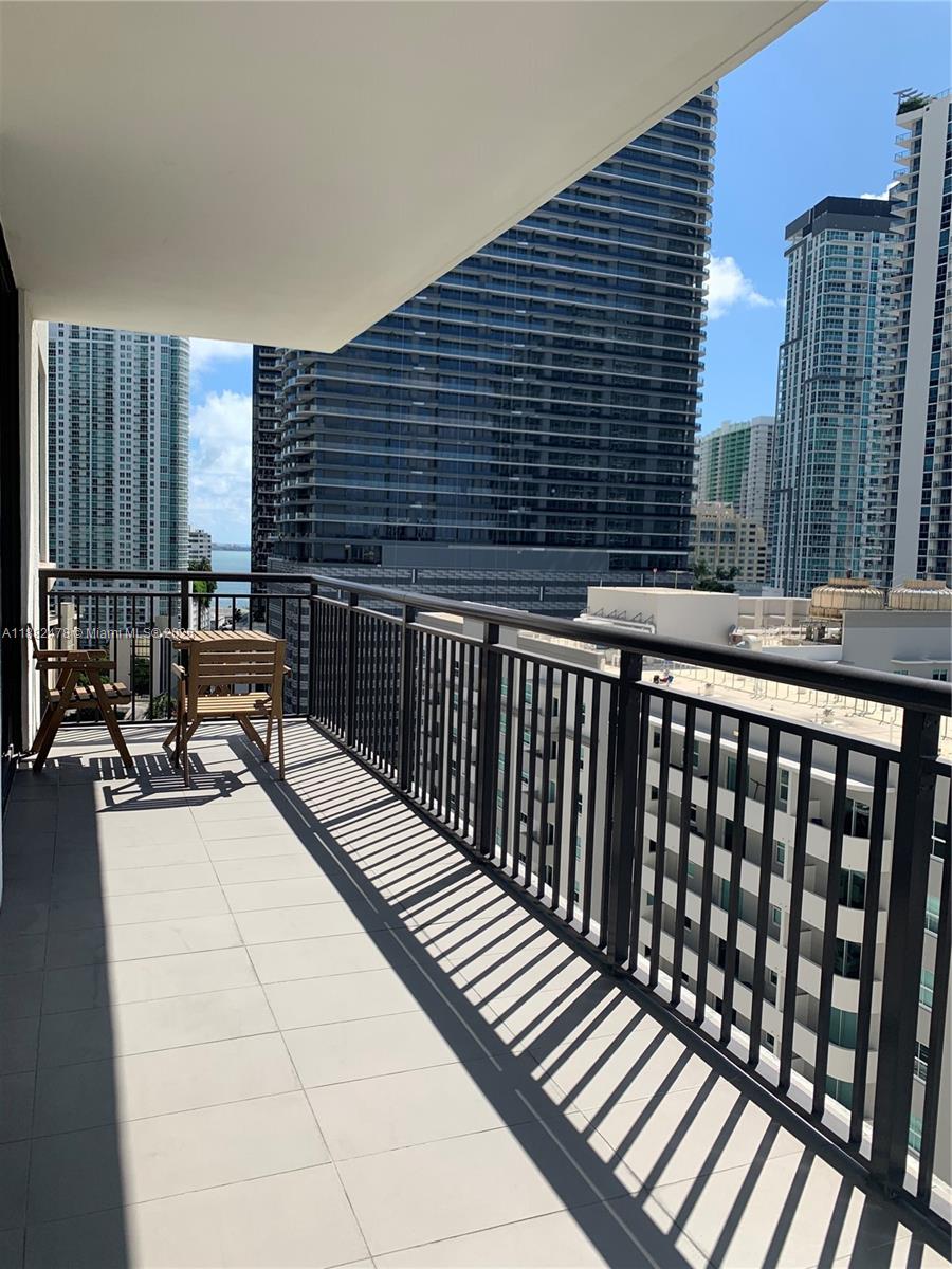 999 Southwest 1st Avenue, Unit 1703 Miami, FL 33130 - Photo 10 of 28 a balcony with table and chairs