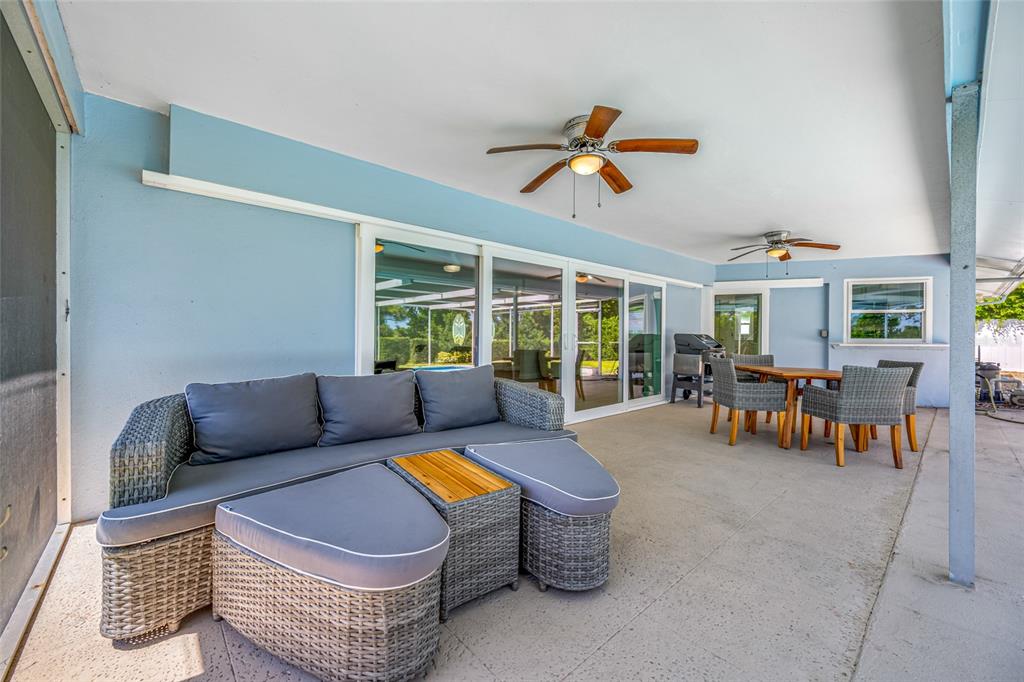 656 Mehlenbacher Road Belleair, FL 33756 - Photo 22 of 49 a living room with furniture and a dining table with floor to ceiling window