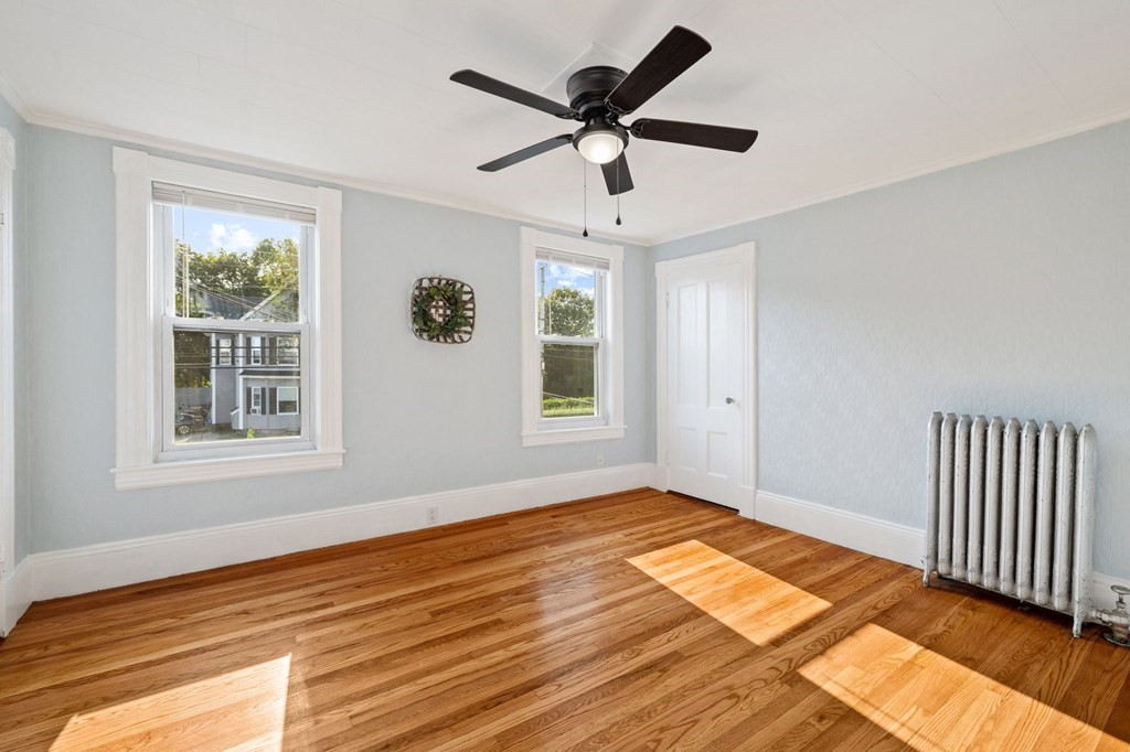 253 Mammoth Road Lowell, MA 01854 - Photo 15 of 42 a view of an empty room with a window and wooden floor