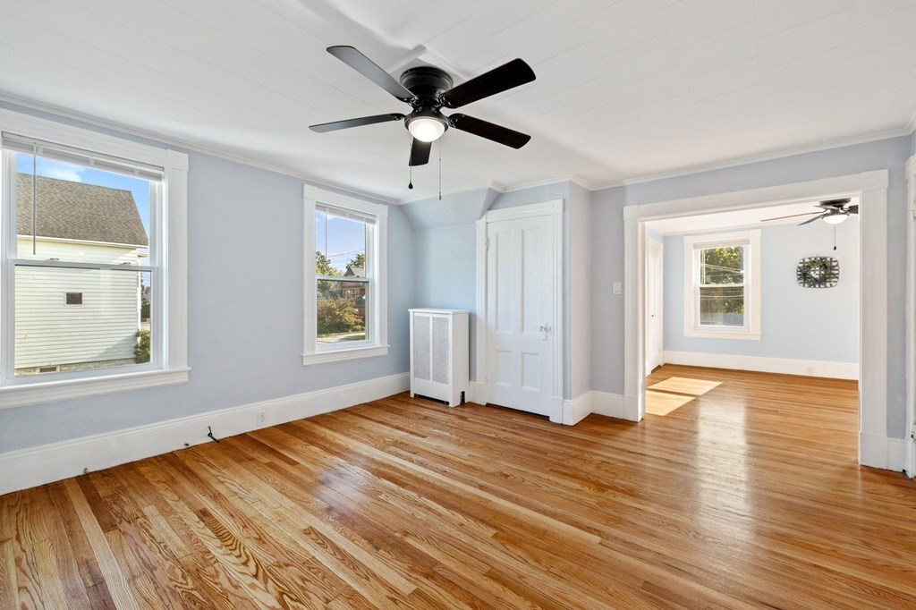 253 Mammoth Road Lowell, MA 01854 - Photo 22 of 42 a view of empty room with wooden floor and ceiling fan