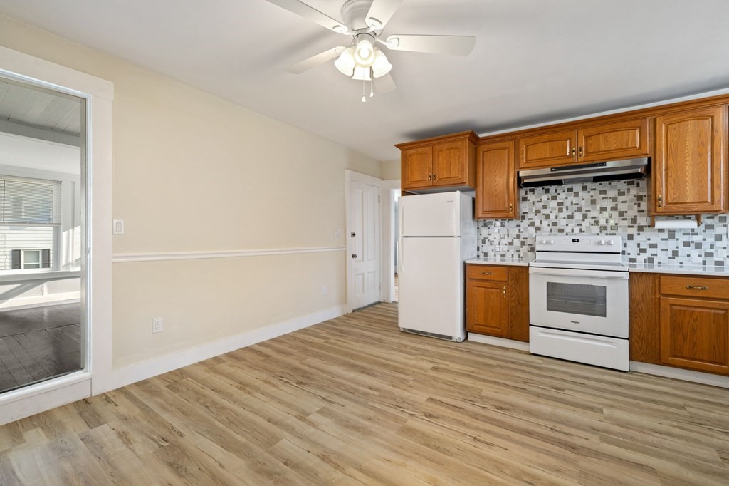 253 Mammoth Road Lowell, MA 01854 - Photo 32 of 42 a kitchen with granite countertop a stove cabinets and wooden floor