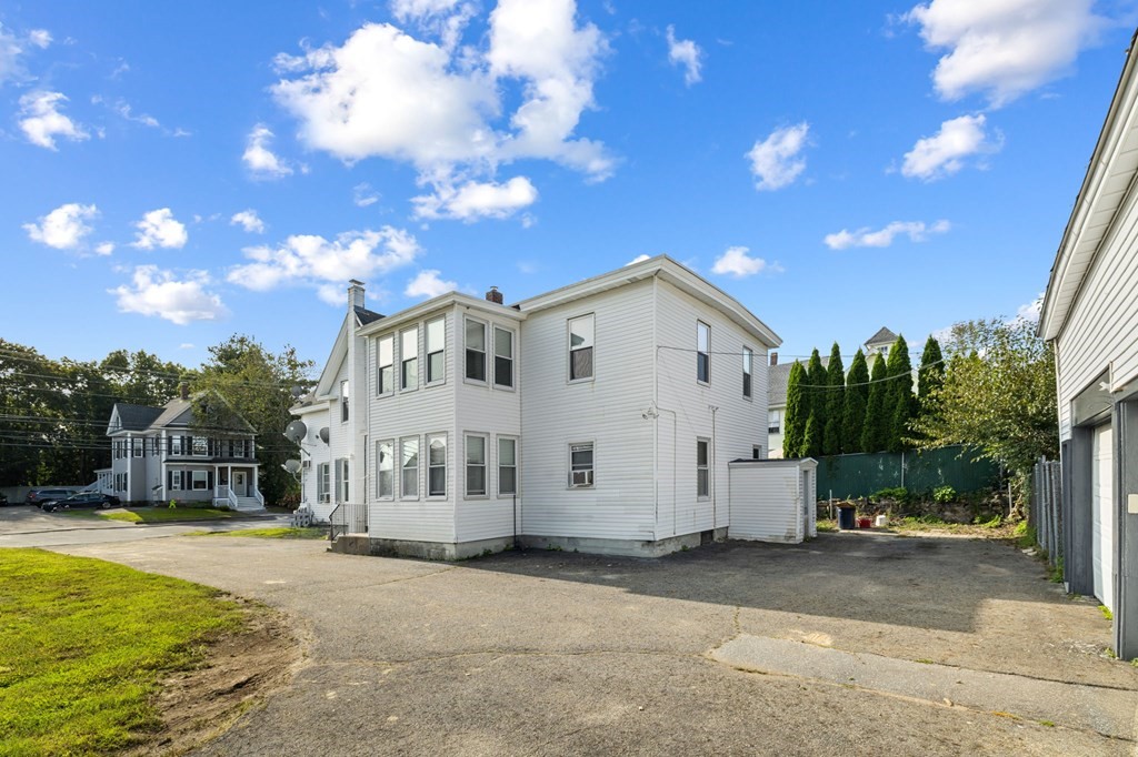 253 Mammoth Road Lowell, MA 01854 - Photo 5 of 42 a view of a white house with a yard