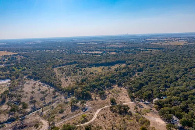 an aerial view of house with yard and mountain in the background