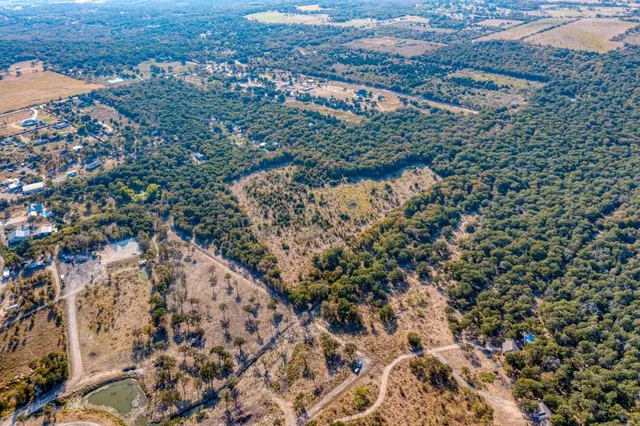 an aerial view of house with yard and mountain view in back