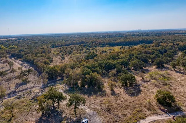 an aerial view of house with yard and mountain view in back