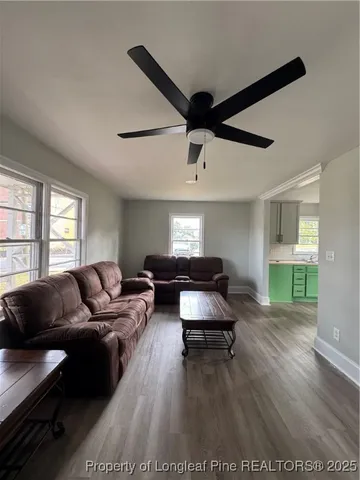 a living room with furniture and a wooden floor