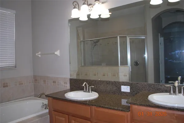 a bathroom with a granite countertop sink a mirror and a bathtub