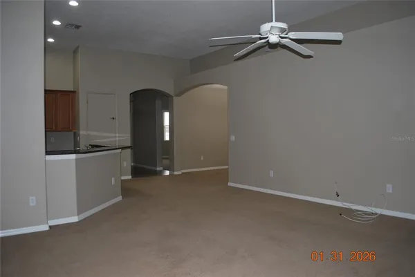 an empty room with a ceiling fan and a window