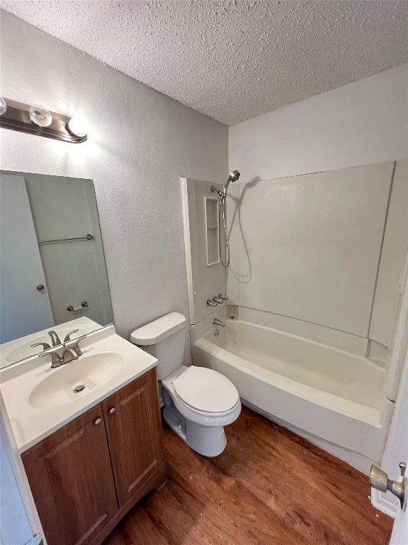 2307 Rachael Court, Unit D Austin, TX 78748 - Photo 3 of 8 Bathroom featuring dark wood-style flooring, vanity, a textured ceiling, washtub / shower combination, and a textured wall