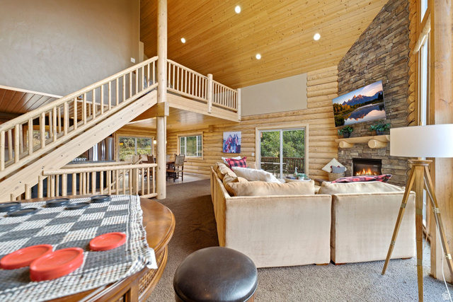5404 Mountain View Road Coalville, UT 84017 - Photo 9 of 50 Spacious living area featuring a stone-clad fireplace, wood-finish walls, exposed wood ceiling, and an open loft