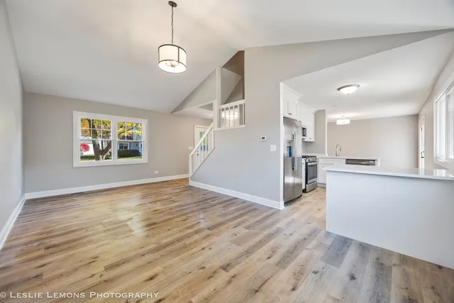 a view of a kitchen with wooden floor and a window