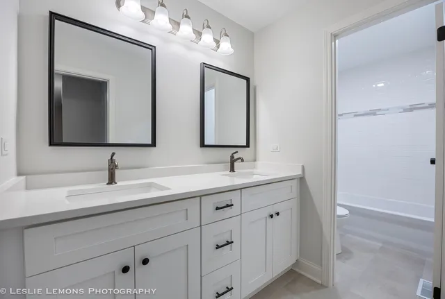 a bathroom with double sink and a mirror