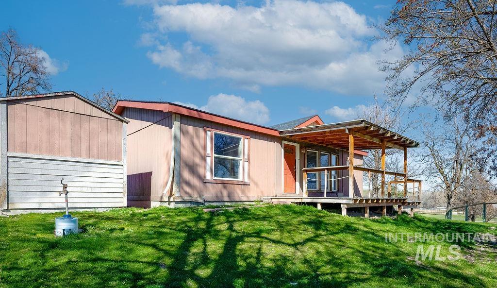 7370 Sagebrush Lane Caldwell, ID 83607 - Photo 26 of 40 Rear view of property with a lawn, a storage shed, and a wooden deck