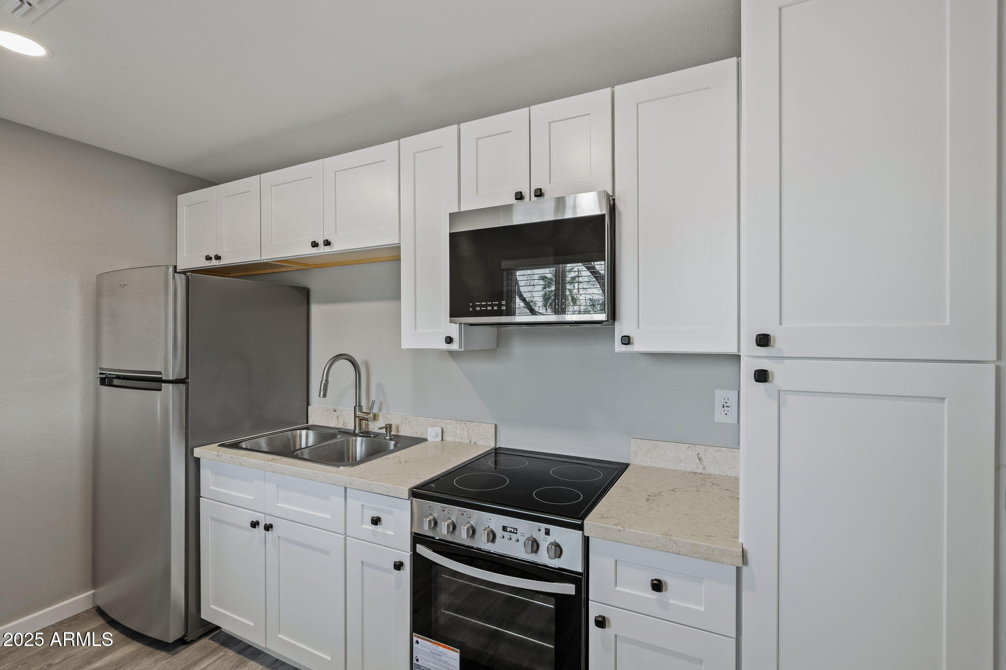 1940 West Amelia Avenue, Unit 1940 Phoenix, AZ 85015 - Photo 12 of 17 a kitchen with cabinets and a stove top oven