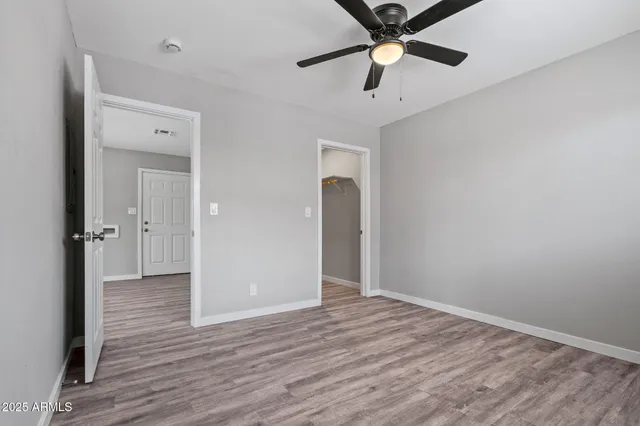 wooden floor in an empty room with a fan