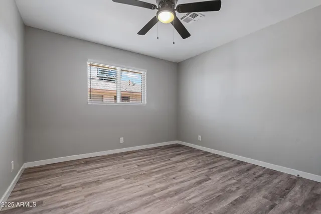 a view of room with hardwood floor and ceiling fan