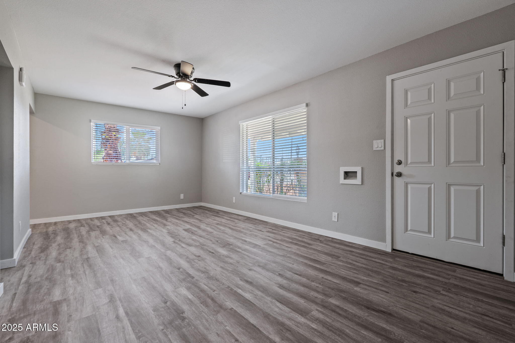 1940 West Amelia Avenue, Unit 1940 Phoenix, AZ 85015 - Photo 5 of 17 an empty room with wooden floor ceiling fan and windows