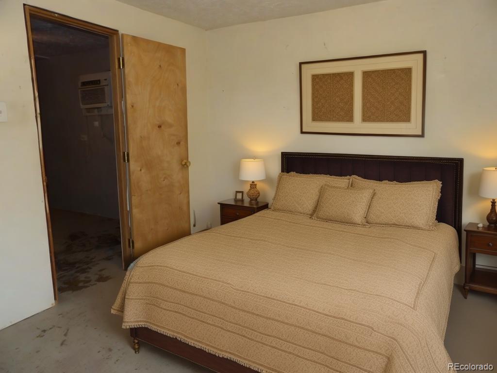 1002 Frontier Street Pueblo, CO 81006 - Photo 14 of 26 a bedroom with a bed and a painting on the wall