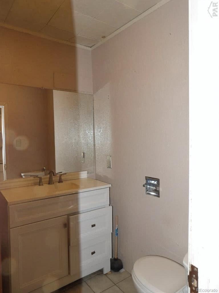 1002 Frontier Street Pueblo, CO 81006 - Photo 7 of 26 a bathroom with a granite countertop toilet sink and mirror
